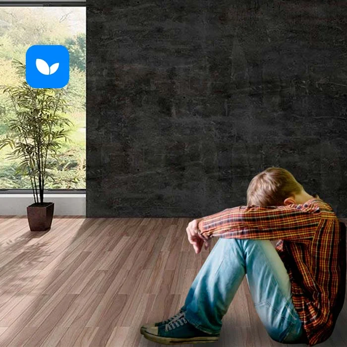 Грустный мальчик сидит на полу